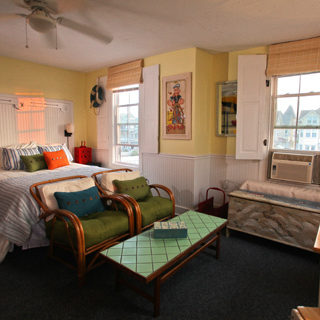 A bedroom with bed, sofas and a side table